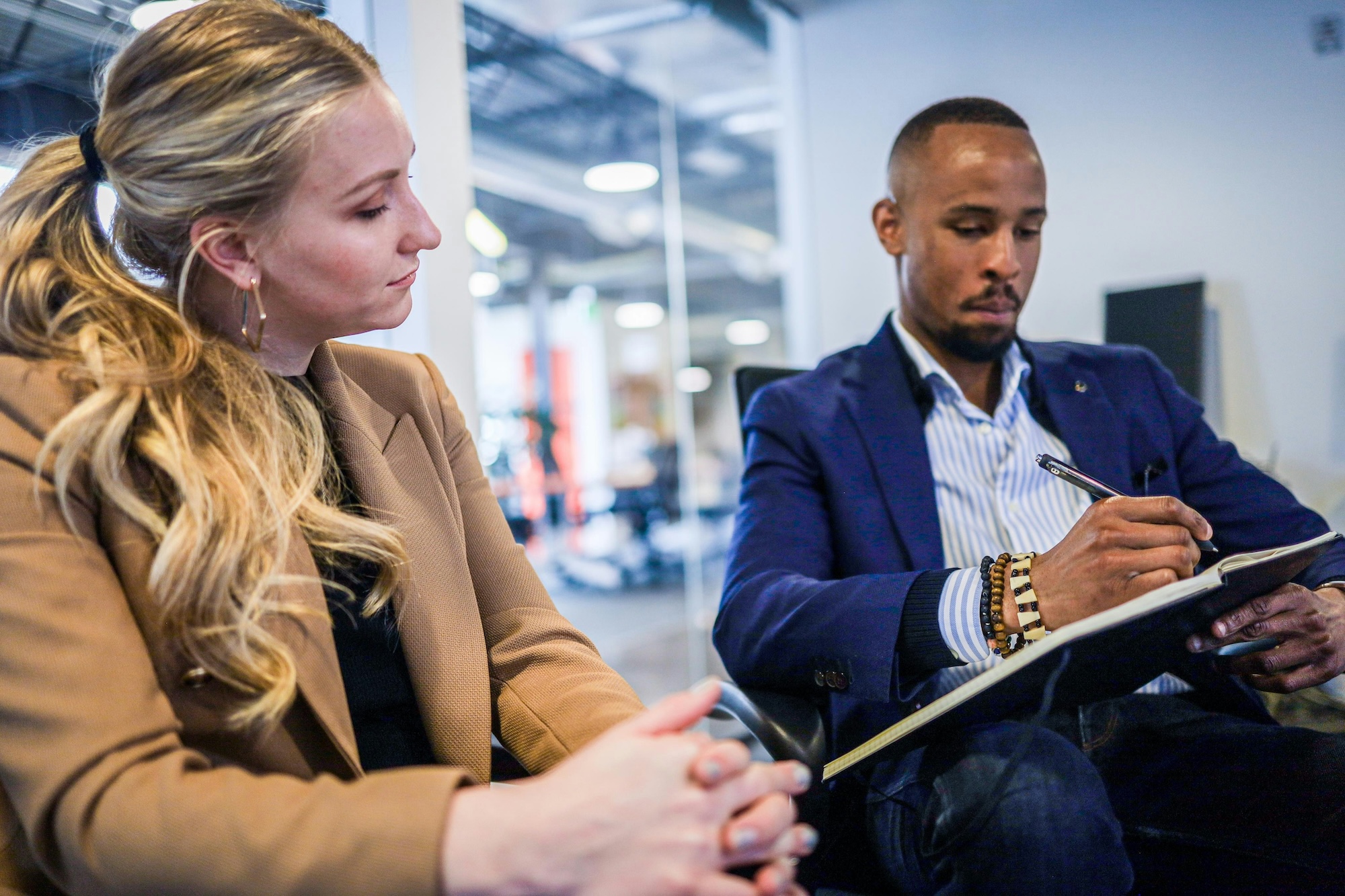 two people sitting and going over a piece of paper on a clipboard